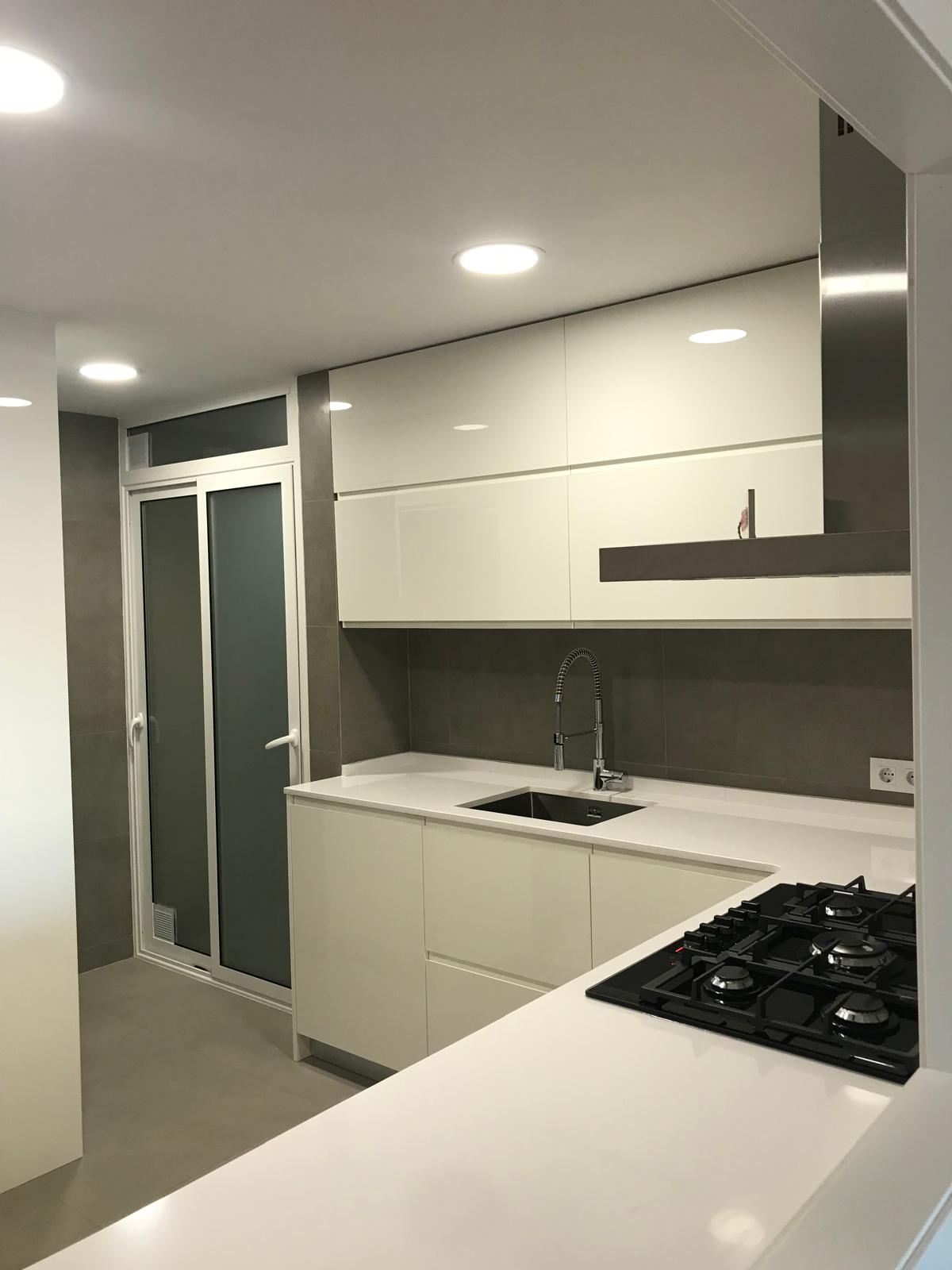Reforma integral con cocina abierta de muebles blancos en L'Eixample, Barcelona
