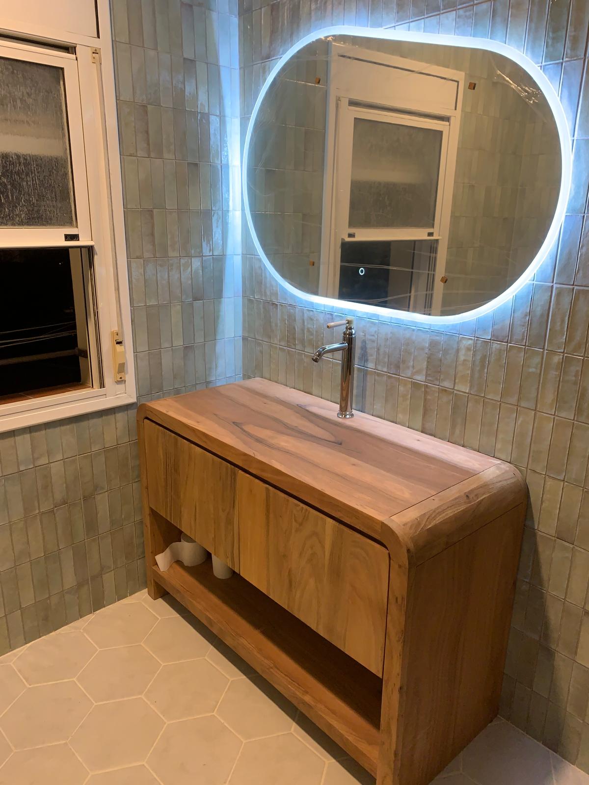 Baño principal reformado con mueble suspendido y espejo retroiluminado